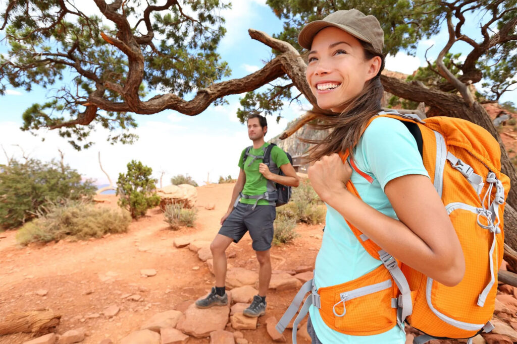 man and woman hiking in rocks and desert