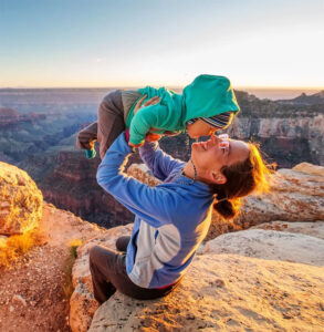 mother holding baby sitting in desert nature